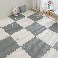 Gray and white checkered foam puzzle mat in a room with toys and a small table.