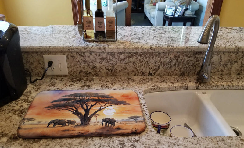 Decorative dish drying mat with tree and elephant design on a kitchen counter.