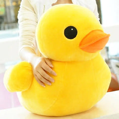 Large yellow rubber duck plush toy held by a person.
