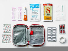 First aid kit with various medical supplies on a white background