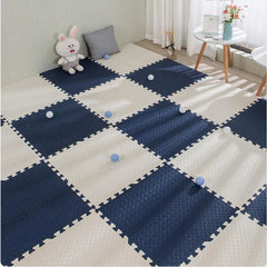 Checkered foam mat in blue and white on a floor with a toy and pillows in the background.