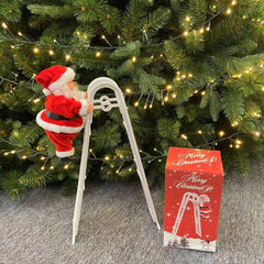 Santa Claus decoration with a ladder and a matching box in front of a Christmas tree.