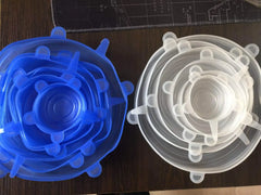 Blue and clear silicone stretch lids on a dark surface