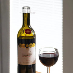 Bottle of red wine with a glass of wine on a neutral background
