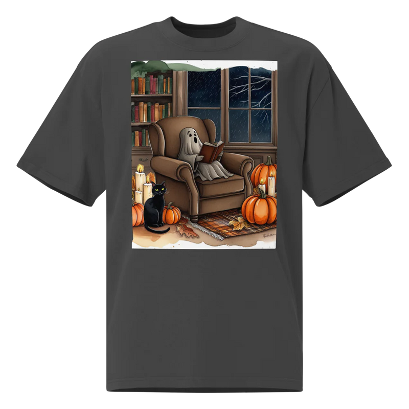 Black t-shirt with a Halloween-themed graphic of a ghost sitting in an armchair reading a book,beside a window showing dark sky and rain outside, with tree branches, cat, and pumpkins beside the chair