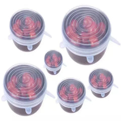 Set of silicone food covers on containers with red contents on a white background