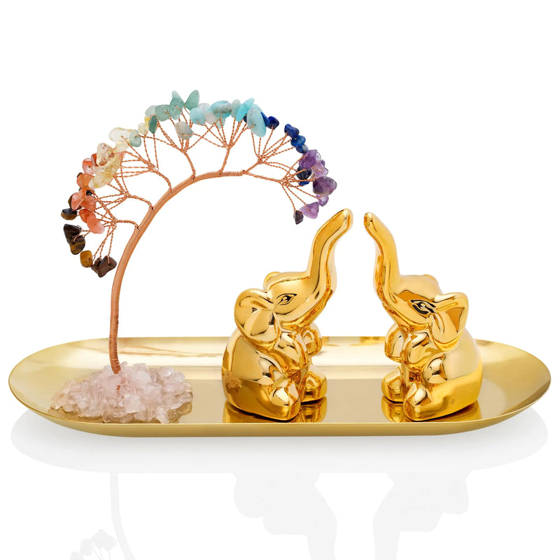 Decorative set with gold elephants, a crystal tree, and stones on a white background