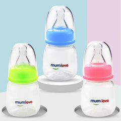 Three baby bottles with colourful caps and 'mumlove' branding on a light blue and pink background.