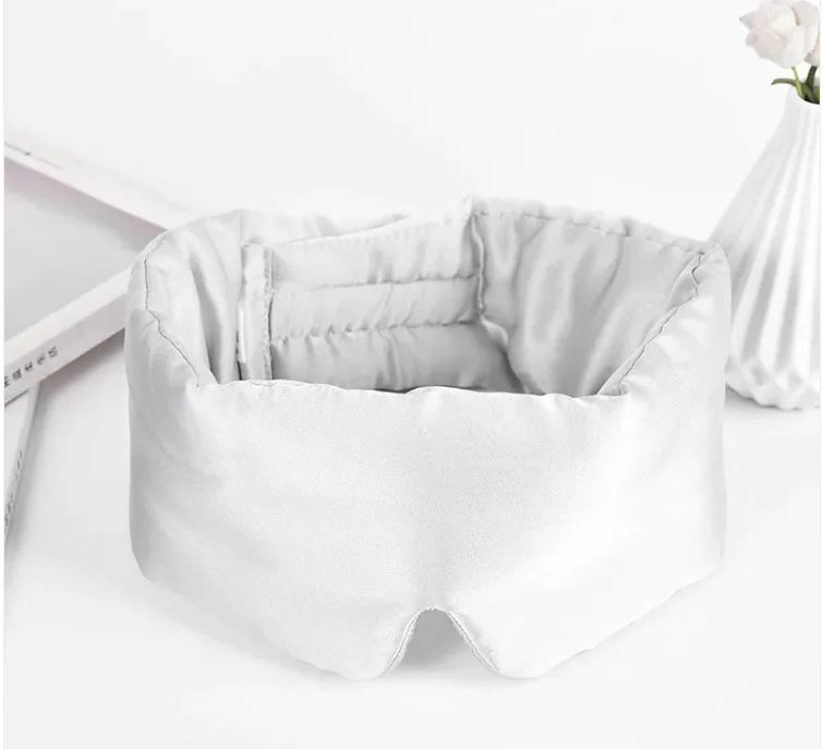 White sleep mask on a white surface with a minimal background