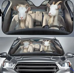 Car sunshades with cartoon goats in a car and on a car windshield.