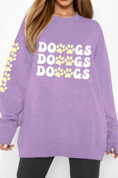 A purple sweatshirt with 'DOGS DOGS DOGS' text with pawprints between the Os and the Gs, and down the right arm
