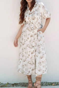 Casual button down the front collared white dress with puffy sleeves and floral print in neutral tones.Pockets in the skirt.