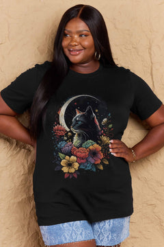 Black tshirt with short sleeves, round neck and styized design of long haired cat with blue eyes surrounded by blooming flowers with the glow of a sliver moon in the background
