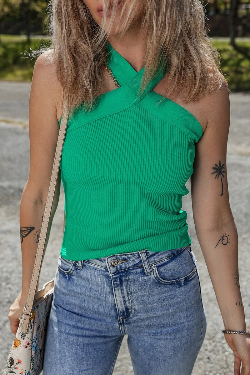 a green top with no sleeves and crisscross in front that gives the appearance of a haltertop, ribbed, clingy fit body that ends at hips

