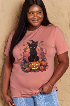 Pink t-shirt with a Halloween design featuring a black cat, pumpkins, leaves and bats in front of full orange moon.