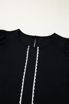 Black dress with white trim on a white background