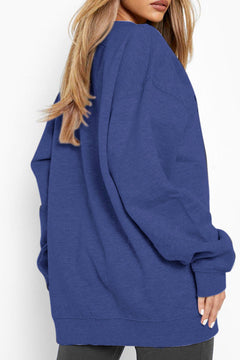 Blue oversized sweatshirt worn by a person on a white background