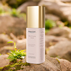 50 ml bottle of Brume d'Avril milky oil foaming cleanser on a sandy stone background