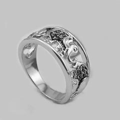 Silver ring with intricate designs on a gray background