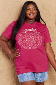 Pink tshirt with round neck and short sleeves, design is all in pink with Gemini above two long haired twins facing away from each other and encircled by a wreath of flowers and leaves.At the bottom of the design is a circle with Roman numeral Two in it.
