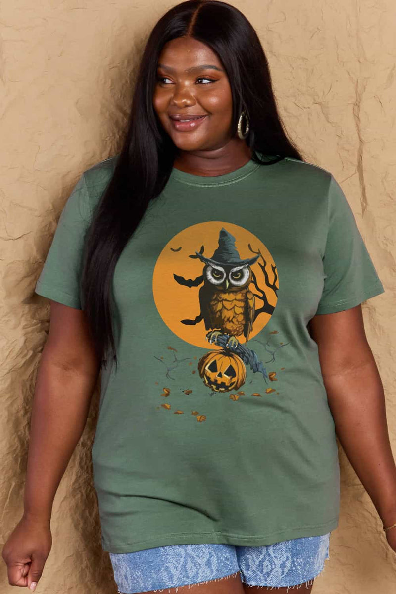 Moss green tshirt with round neck and regular sleeves, Halloween design of full orange moon with an owl wearing a witch hat and sitting on a bare branch, bats flighing around and a jacko'lantern below with a scattering of fall leaves