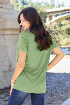 Woman wearing a green t-shirt outdoors with blurred background