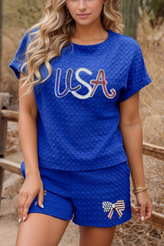 Royal Blue Textured weave shirt and shorts set with USA in blue, white and red letters across the chest, and a red white and blue bow with flag motive on shorts.