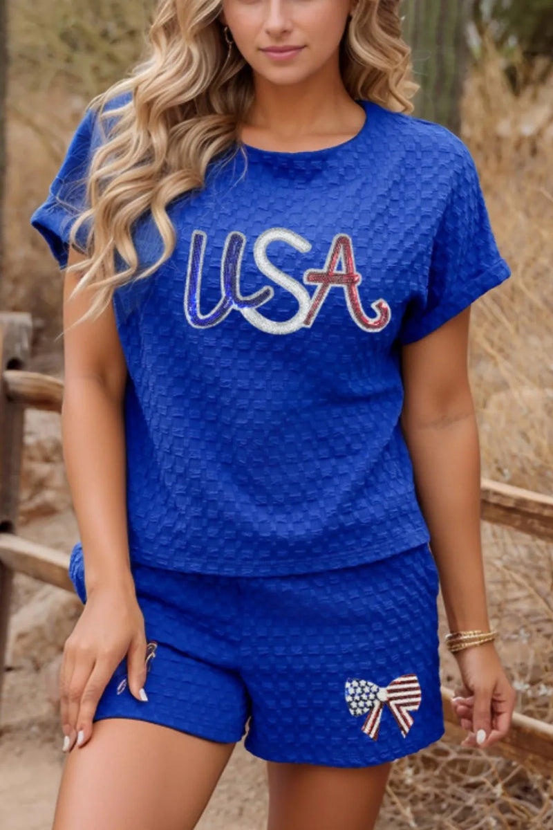 Royal Blue Textured weave shirt and shorts set with USA in blue, white and red letters across the chest, and a red white and blue bow with flag motive on shorts.
