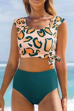 Leopard Print U Neck Knotted High Waist Bikini Set Top is peachy cream color with big leopard spots of gold, outlined in black, and bottom is green. The top straps are wide enough to cover most of the shoulder and the knot is on the left side front