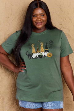 Green t-shirt with Halloween-themed graphics. Four gnomes sitting behind a caldron with green brew bubbling out, a black cat with arched back on the right and a grinning jack o'lantern on the left with black 'sheet' ghosts, a bat and two black jack o' lantern silhouttes hovering above. Each gnome has a long pointy hat in either orange, black, or a combination of the two. The gnome on the left has a witch hat.