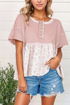 Waffle Floral Patchwork Exposed Seam Detail Short Sleeve Top. Upper shirt is solid pink with 5 tan buttons and lace detail around neck. Bottom half is floral pattern with tan and pink flowers.