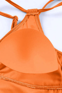 Close-up of an orange bikini top with a white background