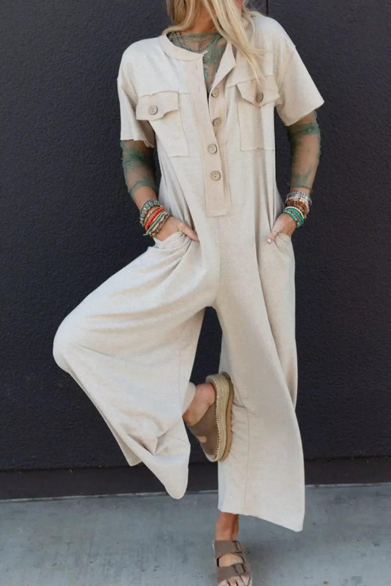 Beige wide leg jumpsuit with buttoned pockets on the chest and hip pockets.Round neck and oversized buttons down the front.