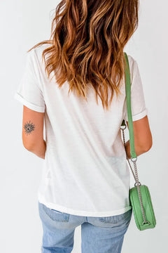 Person wearing a white t-shirt and blue jeans with a green handbag on a plain background
