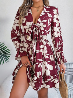 Woman wearing a burgundy floral dress with a white background