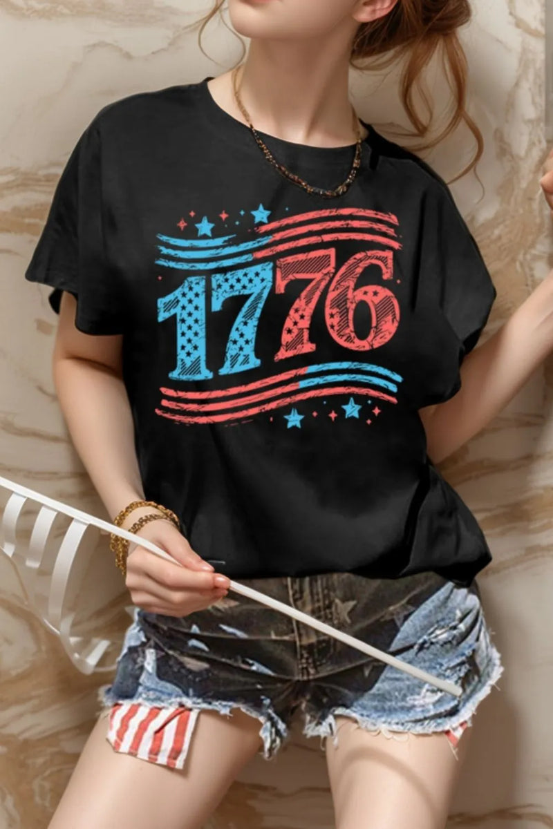 Black Round Neck Short Sleeve T-Shirt with 1776 on the front. The 17 is in blue and the 76 in red. Above the date is three curved stripes that start out blue and change to red and below the date three stripes that start rep and the top two of those end up blue. There are blue and red stars above the top lines on the left and below the bottom right.