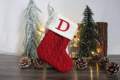 Red Christmas stockings style crew socks with snowflake and 'd' design, surrounded by festive decorations.