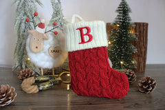 Red Christmas stockings style crew socks with snowflake and 'B' design, surrounded by festive decorations.