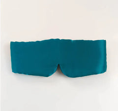 Teal silk sleep mask on a white background