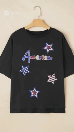 Red headed woman walking down city street wearing the America Tshirt that has red white and blue stars surrounding the word