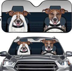 Car sunshade with a design of a dog driving and another dog sitting in the passenger seat, placed on a car.