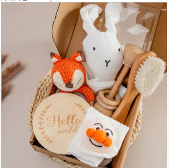 Baby care items including a fox plush toy, white rabbit plush toy, wooden brush, and soap with a smiley face on a neutral background.